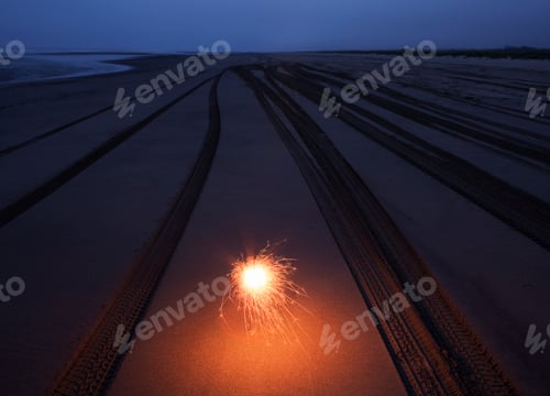 Preview: Sparkler on the Beach,view of tyre tracks in sand at dusk