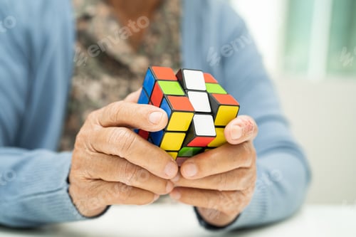 Preview: Alzheimer disease AD, Asian elderly woman patient playing Rubik cube game to practice brain