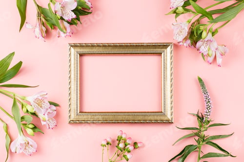 Preview: Golden photo frame with flowers on pastel pink background, copy space