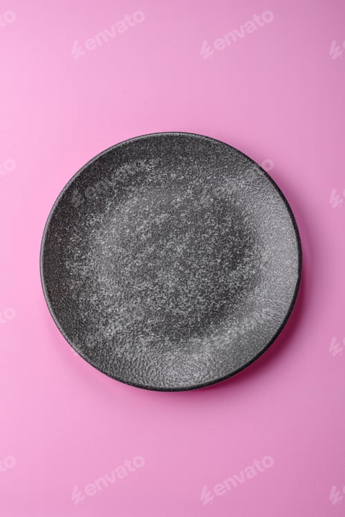 Preview: An empty round ceramic plate on a pink background as a kitchen utensil. An empty plate