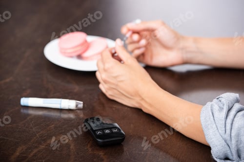 Preview: cropped view of woman holding syringe near sweet dessert