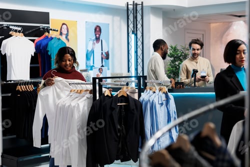 Preview: Woman browsing through shirts rack