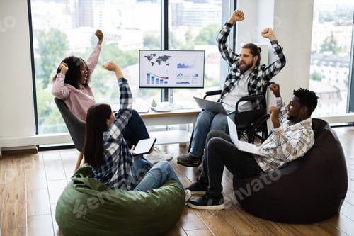 Preview: Team celebrating success together in modern office environment