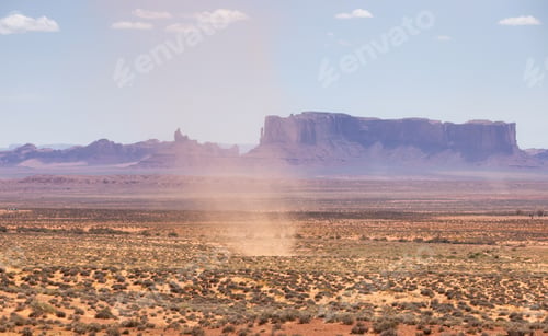 Preview: Dust Devil on a hot sunny day in a desert with red rocky mountains in background