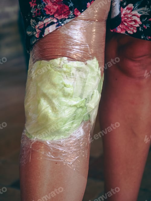 Preview: woman knee wrapped with cabbage leaves compress for anti inflammatory pain relief.