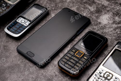 Preview: Many obsoleted cellphones and a smartphone on a grunge background.