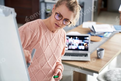 Preview: Young teacher writing on the blackboard while teaching at home