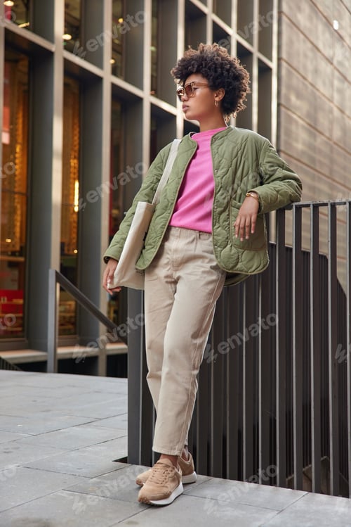 Preview: Full length shot of stylish woman dressed in stylish clothes carries bag recreats on autumn daytime
