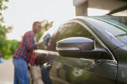 Preview: Woman wipes a car with rag, hand auto wash