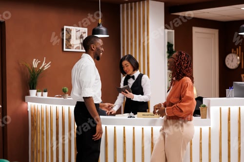 Preview: Hotel worker registering guests in lobby