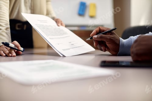 Preview: Close-up of African America CEO signing document in the office.