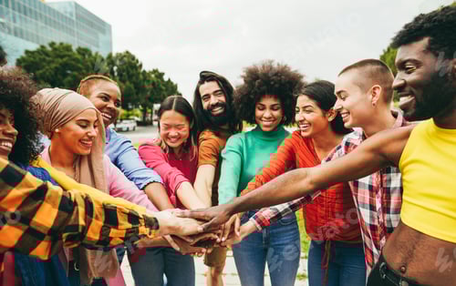 Preview: Young multiethnic people having fun stacking hands outdoor - Focus on hands