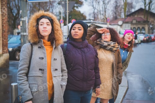 Preview: group of young women standing in the street and looking ahead