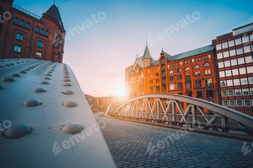 Preview: Iron arch bridges in historical warehouses in Speicherstad district in Hamburg, Germany. Backlit sun