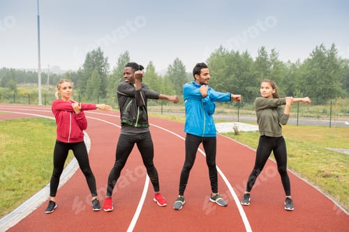 Preview: Young men and women in activewear exercising on race tracks