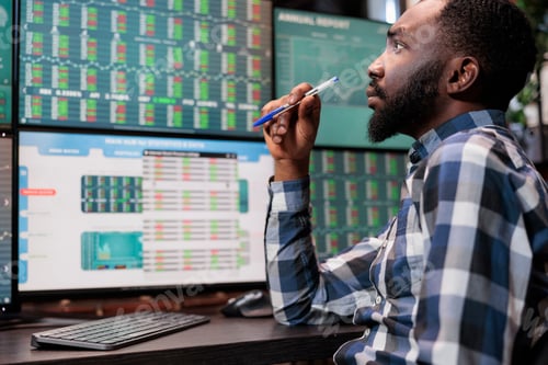 Preview: Busy financial analyst sitting at workstation while reviewing investment fund data and statistics.