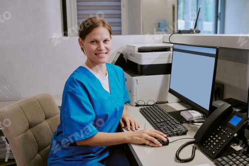 Preview: Portrait of Young Adult Caucasian Woman Working at Computer in Medical Office
