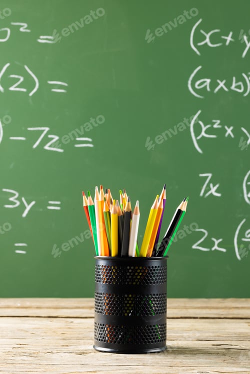 Preview: Image of cup with crayons over mathematical formulas on black board