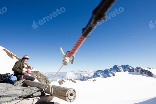 Preview: Male hiker eating snacks on viewing platform, Jungfrauchjoch, Grindelwald, Switzerland