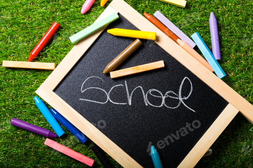 Preview: Top view of mini blackboard and colors on plastic grass background. Concept back to school