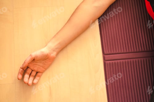 Preview: Yoga at home, detail of a young woman's hand lying on the mat. In the coronavirus quarantine