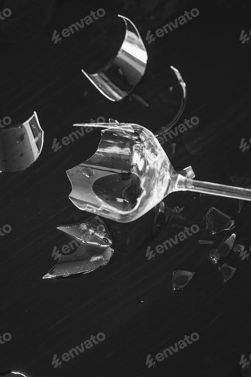 Preview: Broken wine glass with a lot of sharp shards on the table