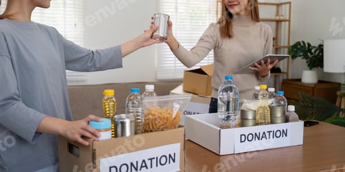 Preview: Volunteer preparing free foodstuff rations for poor people. Charity two woman of the community work