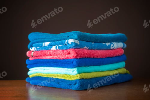 Preview: pile of colorful towels lay in the laundry on washing machine and table b