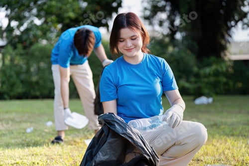 Preview: Young Volunteer Cleaning Up Park Area and Collecting Litter in Black Bags on a Sunny Day