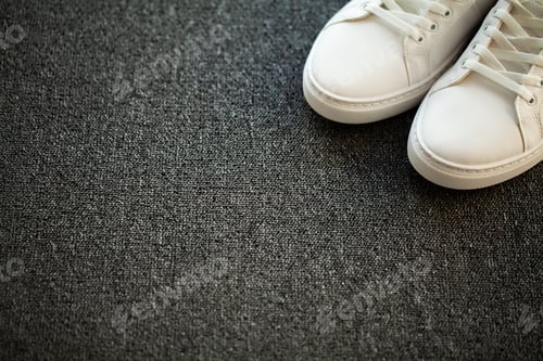 Preview: Pair of new stylish white sneakers on floor at home
