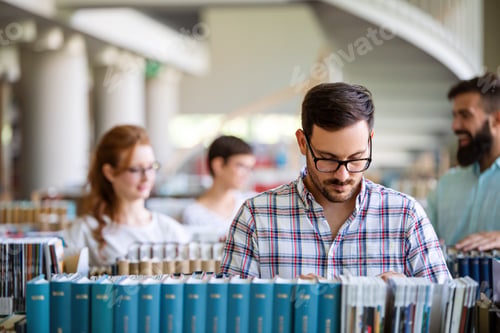 Preview: Happy university students studying with books in library. Group of multiracial people in college