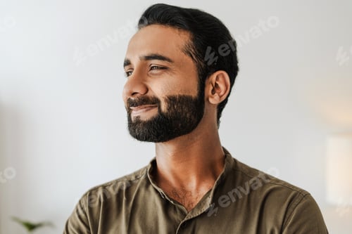 Preview: Portrait of handsome bearded indian man smiling and looking away closeup