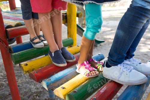 Preview: Low section of friends walking on jungle gym