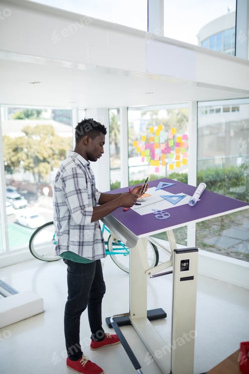 Preview: Male executive working over drafting table