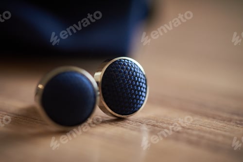 Preview: Closeup of blue ornate cuffs on a wooden table
