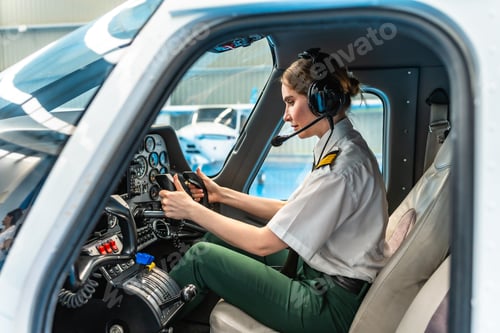 Preview: Female pilot sitting in cockpit and preparing for takeoff