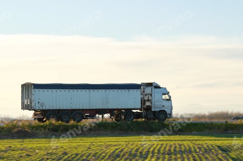 Preview: Semi-truck with tipping cargo trailer transporting sand from quarry driving on highway