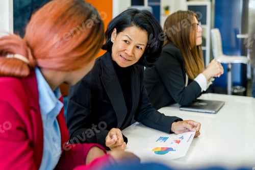 Preview: Group of diverse colleagues analyzing business with statistics in office