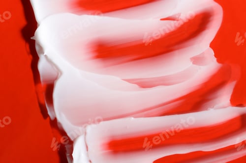 Preview: A sample of body cream on a bright red background close-up. A cosmetic product applied on