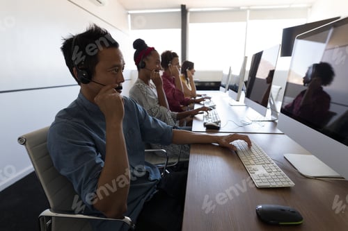 Preview: Executives talking on headset in modern office