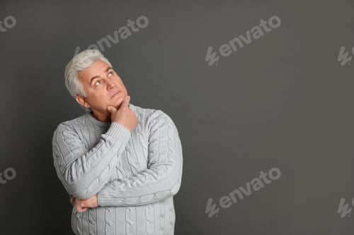 Preview: Thoughtful mature man on dark grey background. Space for text