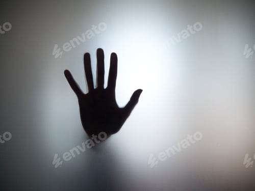 Preview: Silhouette of a hand on a blurred window