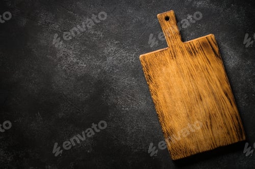 Preview: Wooden cutting board at black stone table.
