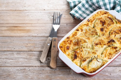 Vista previa: Casserole with cheese and gratin zucchini on wooden table