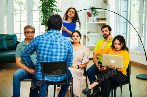 Preview: Indian Business manager guiding his team of young professionals in a cozy creative office setting