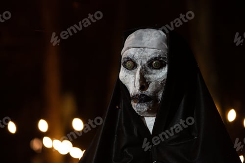 Preview: Scary Halloween witch with red eyes in a black cloak in a gloomy environment