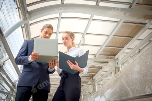 Preview: Two business people with laptop outdoor.