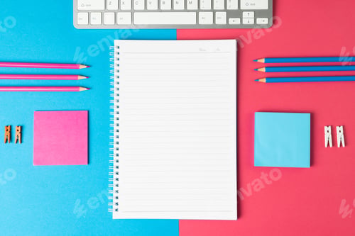 Preview: Composition of notebook with copy space, laptop and school equipment on blue and pink surface