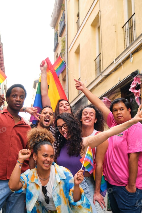 Preview: A group of people are holding rainbow flags and smiling for the camera.