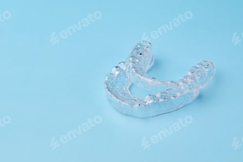 Preview: Close up invisible aligners on the blue background with copy space. Plastic braces dentistry